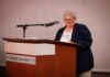 Engineering dean honored with 2026 Mike MacCarthy Mentoring Award An older woman stands at a podium labeled Mercer University, speaking into a microphone.