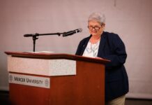 Engineering dean honored with 2026 Mike MacCarthy Mentoring Award An older woman stands at a podium labeled Mercer University, speaking into a microphone.