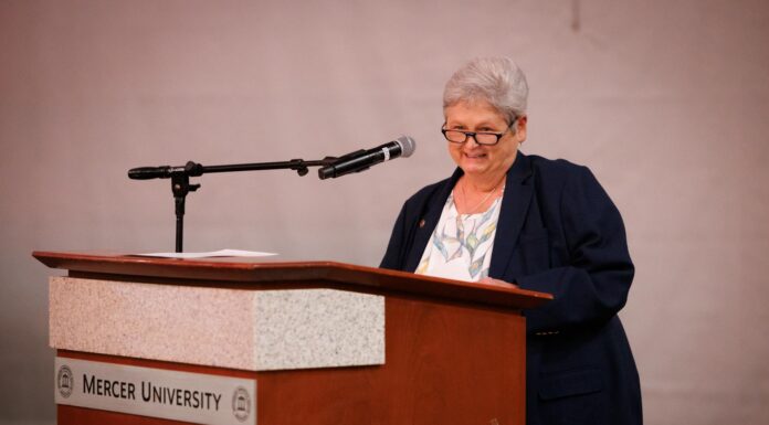 Engineering dean honored with 2026 Mike MacCarthy Mentoring Award An older woman stands at a podium labeled Mercer University, speaking into a microphone.