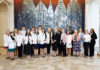 School of Medicine celebrates 2026 Children’s Healthcare of Atlanta Rural Scholars A group of people, some in white coats, stand together indoors in front of a large, geometric stained glass mural.