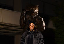 Graduate Spotlight: Deandra Bradley Deandra Bradley, wearing graduation attire, stands in front of a bear statue.