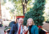 Meet Mercer’s new First Dog: Champ Jason Elkins and Mercer President Dr. Penny L. Elkins sit with a dog in the back of a red truck decorated with Christmas trees and blankets.