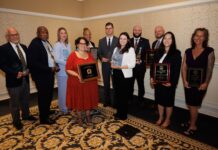 Mercer celebrates faculty achievement at 2026 awards ceremony Ten people stand in a room holding plaques and trophies, posing for an award ceremony group photo.