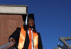 Graduate Spotlight: Nicholas Milsap Nicholas Milsap in cap and gown stands on outdoor steps, wearing an orange sash and matching tie and sneakers.