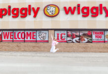 Mercer senior’s gluten-free cake mix now in stores, online Person jumps in front of a Piggly Wiggly grocery store with large red signage and welcome banners on the windows.