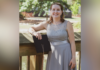 An ode to working adult students as they cross the finish line A woman in a gray dress stands outside on a wooden railing, holding a black folder and smiling at the camera.