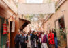Morocco trip opens students’ eyes to international health interventions A group of people pose together in an outdoor hallway beneath a large banner reading Alnour Marrakech.