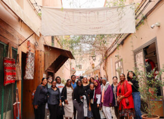 Morocco trip opens students’ eyes to international health interventions A group of people pose together in an outdoor hallway beneath a large banner reading Alnour Marrakech.