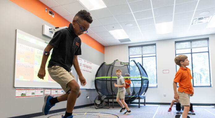 Professor studies impact of physical activity on attention in kids with dyslexia Three boys participate in physical activities in a classroom with exercise equipment and a trampoline in the background.