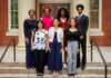 Twelve students selected to study abroad as Gilman Scholars Seven people stand in two rows on steps outside a brick building with columns, facing the camera and smiling.