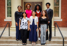Twelve students selected to study abroad as Gilman Scholars Seven people stand in two rows on steps outside a brick building with columns, facing the camera and smiling.