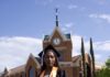 Graduate Spotlight: Olivia Harris Olivia Harris in cap and gown stands on grass in front of Tarver Library.