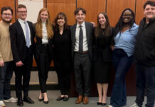 Mercer Law advocacy rises to No. 3 nationally in Gavel Rankings Eight people stand side by side indoors, dressed in business and casual attire, smiling toward the camera.