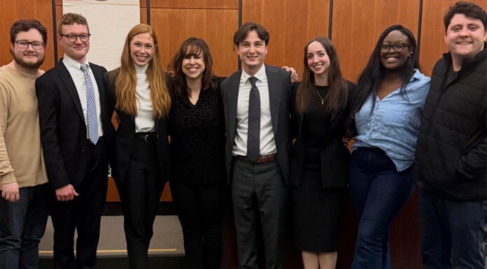 Mercer Law advocacy rises to No. 3 nationally in Gavel Rankings Eight people stand side by side indoors, dressed in business and casual attire, smiling toward the camera.