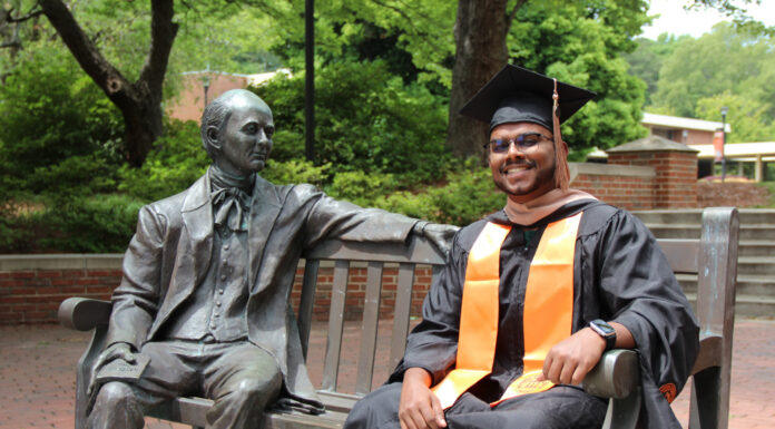 Graduate Spotlight: Samuel Pulapakuri Samuel Pulapakuri, in cap and gown, sits smiling on a bench next to the Jesse Mercer statue in Atlanta.