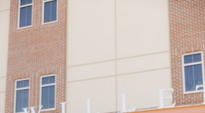 Graduate Spotlight: Teresita Cabral Teresita Cabral in cap and gown sits on steps outside the Willet Science Center, holding up her cap and smiling.