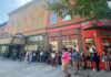 Phoebe Bridgers brings secret show to Mercer’s Robins Financial Capitol Theatre A group of people waits in line outside a theater and nearby restaurants on a city sidewalk.