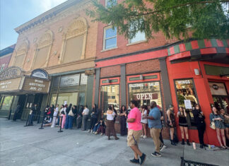Phoebe Bridgers brings secret show to Mercer’s Robins Financial Capitol Theatre A group of people waits in line outside a theater and nearby restaurants on a city sidewalk.