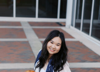 Graduate Spotlight: Cathy Le Woman in a white dress kneeling on brick pavement, holding a bouquet, wearing a sash that reads Vice President.