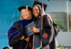 Mercer scholar-athlete Bears post record year in the classroom A graduate and faculty member in academic regalia smile and pose together at a graduation ceremony.