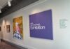 McEachern Art Center opens summer exhibition, relaunches membership program A gallery wall displays art and a large purple sign reading 2026 Summer Artist Exhibition with a list of artists names.