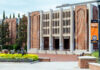 Mercer team develops innovative tools for analyzing climate data Brick building with three entrances, decorative façade, and flowerbeds in front; orange banner on the right.