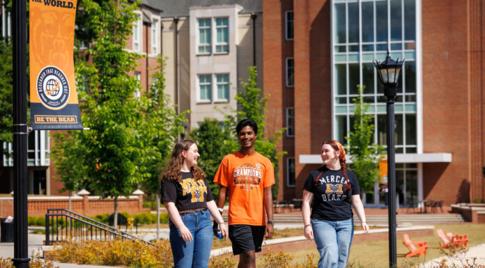 Class of 2026 graduates offer this advice to incoming students Three students walk and talk on a college campus sidewalk near a Be the Bear banner and brick buildings.