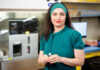 Mercer School of Medicine awarded $100,000 cancer research grant Dr. Chefetz Menaker in teal dress holding a small tube while standing in the laboratory where her research will take place.