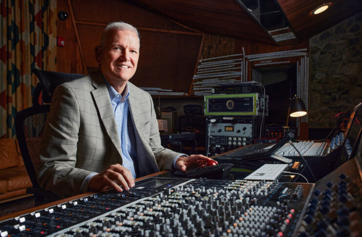 Gary Gerber sits at a large audio mixing console in Capricorn Sound Studios.