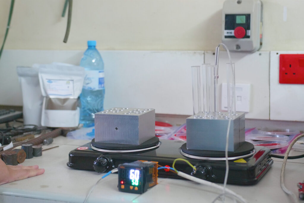Two metal blocks on a double hot plate with a digital temperature display in a laboratory setting.