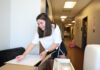 Wandering your way home | Greg DeLoach, Ph.D. A Mercer student unpacks a box in a hallway, surrounded by moving boxes and furniture.