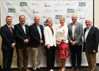 Alumna Chloe Paulk selected as Georgia Student Finance Commission Moment of Impact speaker Seven people standing in a row and posing for a photo in front of a Georgia Match event backdrop.