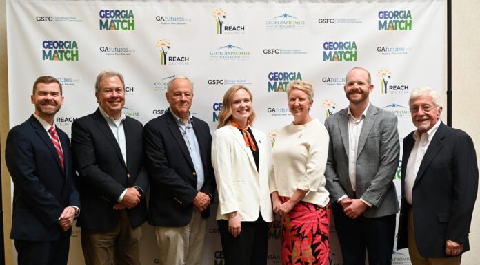 Alumna Chloe Paulk selected as Georgia Student Finance Commission Moment of Impact speaker Seven people standing in a row and posing for a photo in front of a Georgia Match event backdrop.