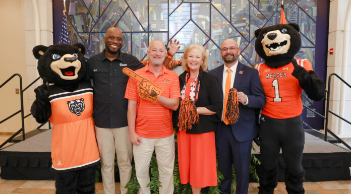 Mercer unveils plans for nationally televised FCS kickoff, free concert series Five people, including two bear mascots, pose on stage with pom-poms and a foam finger at an indoor event.