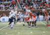 4 things to know about Mercer vs. East Texas A&M football game day: Aug. 29, 2026 Two college football teams line up at the line of scrimmage during a daytime game, with fans watching in the stands.