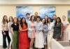 Mercer Law receives top national honor for Student Bar Association A group of fourteen people stand indoors, smiling at the camera, in front of two abstract blue and green paintings.