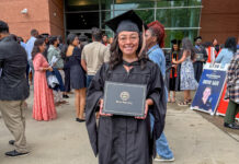 Mercer alumna creates home services directory for women Alicia Hernandez holds a diploma outside a building, surrounded by people at a graduation ceremony.