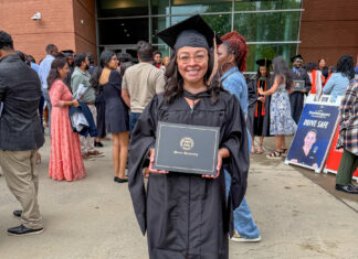 Mercer alumna creates home services directory for women Alicia Hernandez holds a diploma outside a building, surrounded by people at a graduation ceremony.