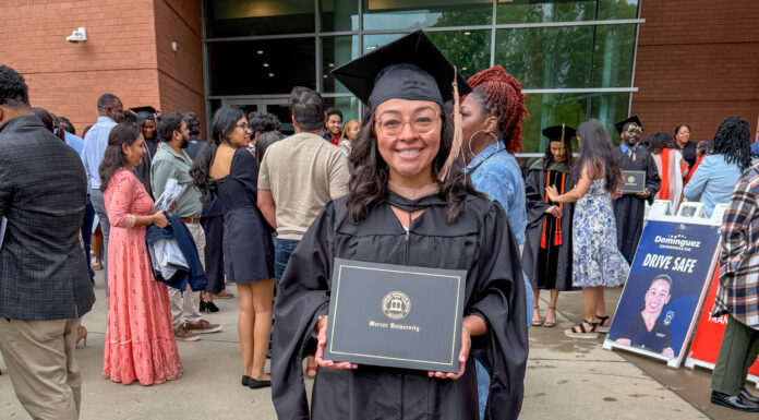 Mercer alumna creates home services directory for women Alicia Hernandez holds a diploma outside a building, surrounded by people at a graduation ceremony.