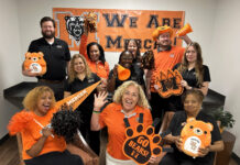 Show your Mercer spirit each week during Be the Bear Fridays This enthusiastic group in Mercer gear poses with pom-poms, banners, and signs, showing school spirit for the Mercer Bears.