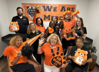 Show your Mercer spirit each week during Be the Bear Fridays This enthusiastic group in Mercer gear poses with pom-poms, banners, and signs, showing school spirit for the Mercer Bears.