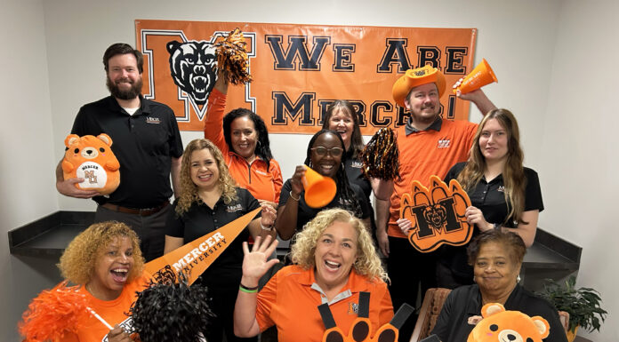 Show your Mercer spirit each week during Be the Bear Fridays This enthusiastic group in Mercer gear poses with pom-poms, banners, and signs, showing school spirit for the Mercer Bears.