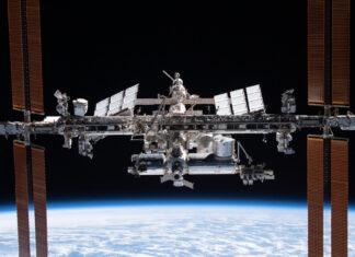 Engineering alumnus helping lead the way in space exploration The International Space Station orbits above Earth with solar panels extended against the blackness of space.