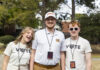 Mercer recognized among best in the country for building and fostering nonpartisan civic engagement Three smiling young adults stand outdoors wearing event lanyards and Mercer-themed shirts, with trees in the background.