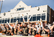 3 things to know about Mercer vs. Presbyterian football game day: Sept. 5, 2026 A group of fans with painted chests and foam sticks cheer in front of Five Star Stadium on a sunny day.