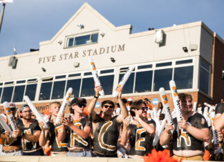 3 things to know about Mercer vs. Presbyterian football game day: Sept. 5, 2026 A group of fans with painted chests and foam sticks cheer in front of Five Star Stadium on a sunny day.