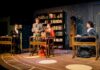 Mercer Theatre play honors female astronomy pioneers Four people in period costumes sit or stand at desks on a stage set resembling a vintage classroom with bookshelves.