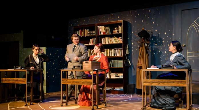 Mercer Theatre play honors female astronomy pioneers Four people in period costumes sit or stand at desks on a stage set resembling a vintage classroom with bookshelves.
