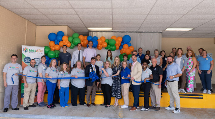 Kids Alliance for Better Care celebrates Elbert Memorial Hospital’s emergency department as part of Pediatric Emergency Care Project A group of people at a ribbon-cutting event stand in front of balloons with a kidsABC sign visible on the left.