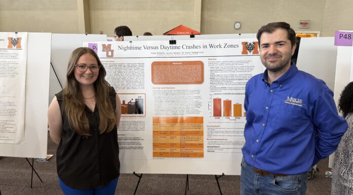 Senior awarded transportation engineering scholarship Two people stand in front of a research poster about nighttime versus daytime crashes in work zones at a presentation event.
